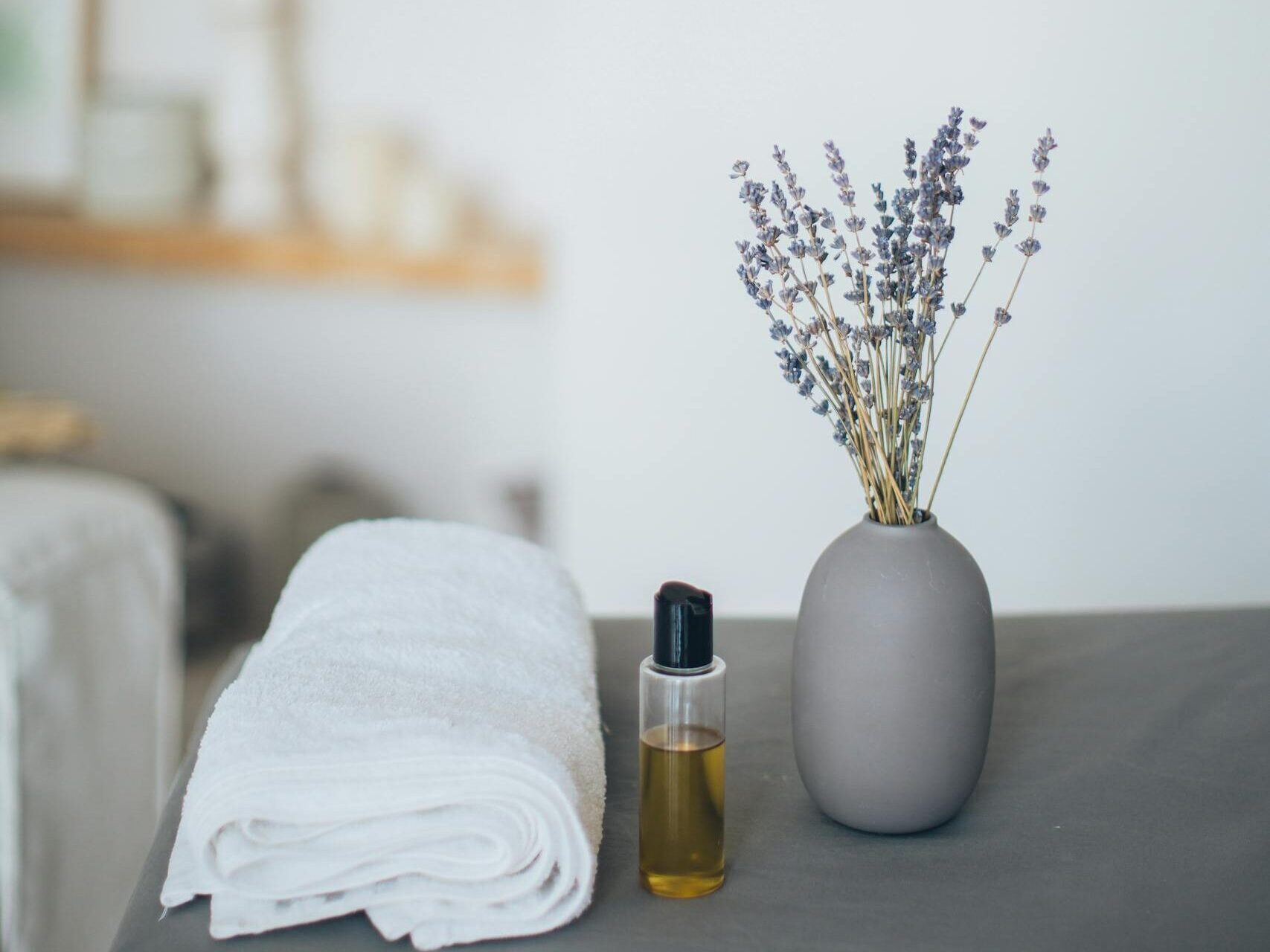 Relaxing spa scene featuring lavender, towel, and oil for a calming experience.